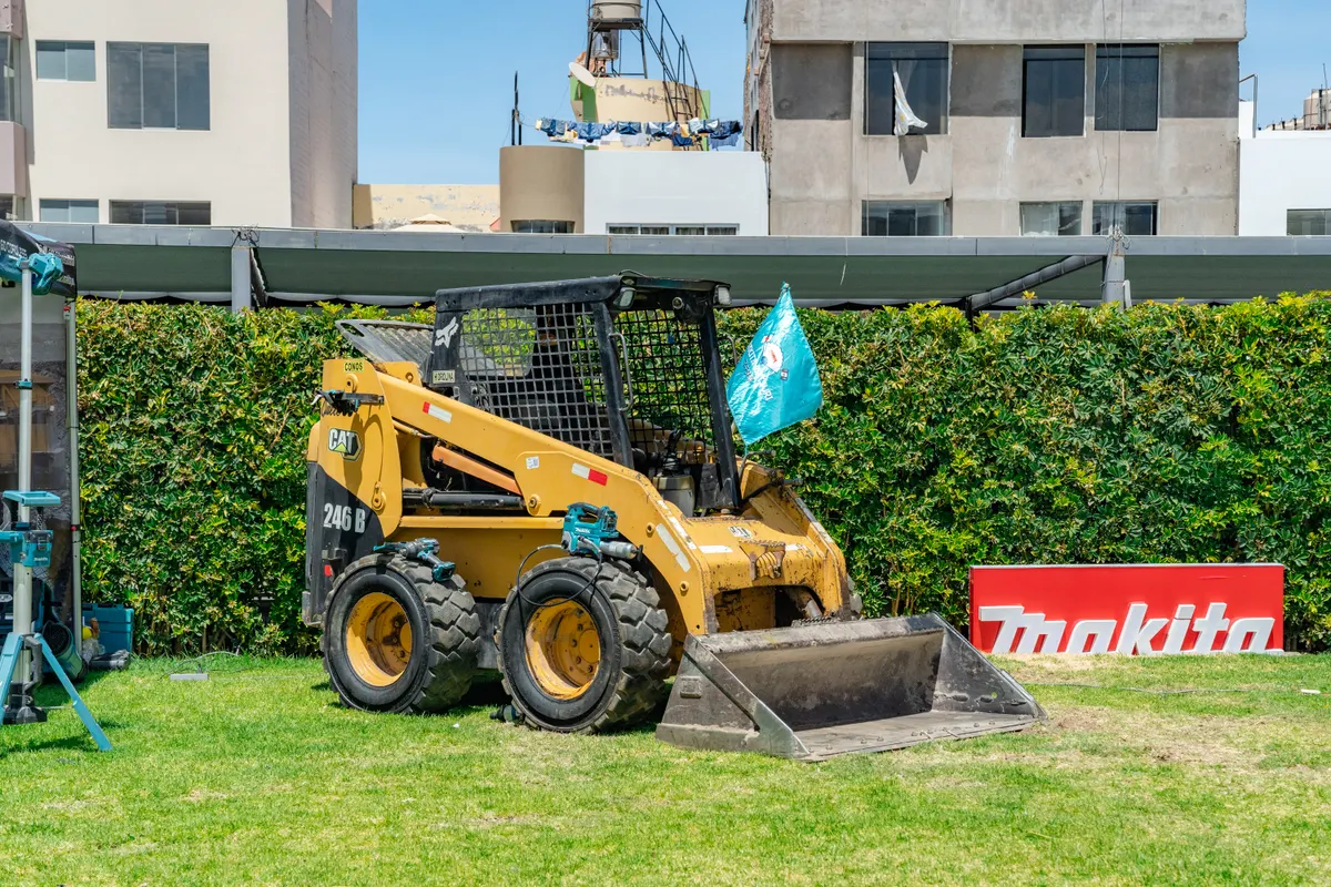 Minicargador y banner de Makita en el área de exhibición